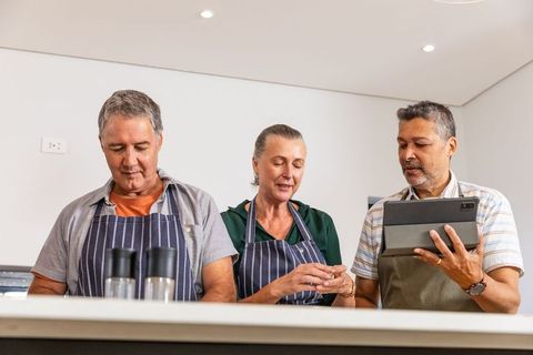 Senior Friends Cooking Together, Following Recipes on Tablet