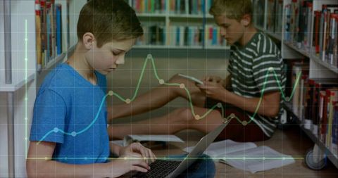 Two boys typing and reading in library using laptop and tablet with data graph overlay
