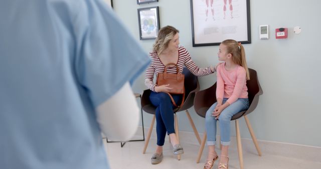 Mother comforting daughter in waiting area of medical clinic - Download Free Stock Images Pikwizard.com