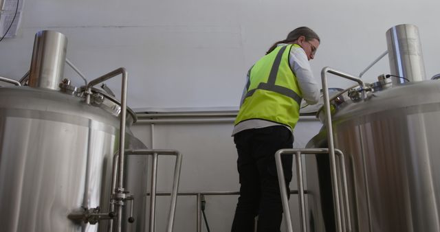 Worker Inspecting Industrial Brewing Equipment in Modern Brewery - Download Free Stock Images Pikwizard.com