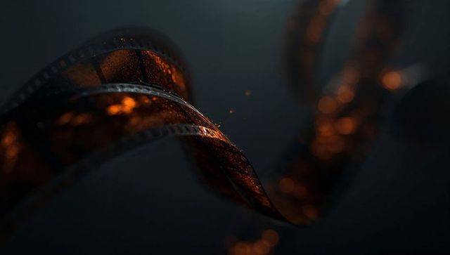 Twisted Film Strip Under Dramatic Lighting with Water Droplets