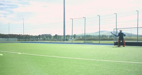 Goalkeeper holding stick ready in field hockey game