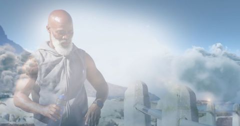 Fit Senior Man Exercising with Hydration Under Majestic Clouds