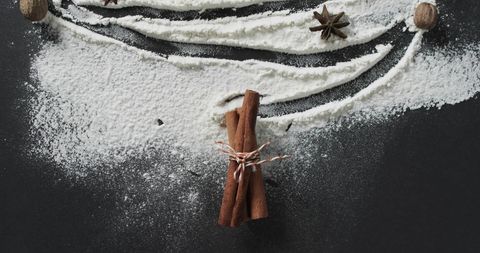 Cinnamon Sticks with Flour and Star Anise on Dark Surface