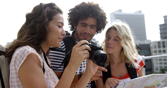 A diverse group of young friends are reviewing photos on a camera during a city outing, with copy space. Capturing memories, they share a moment of connection as they navigate their urban adventure.