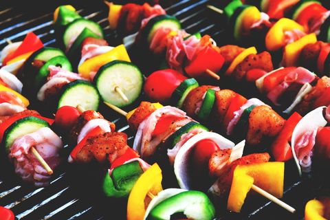 Grilling colorful chicken and vegetable skewers on outdoor grill for summer barbecue