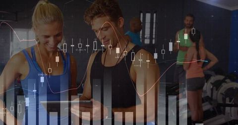 Gym trainers checking tablet with overlaid data charts and fitness analytics visualization