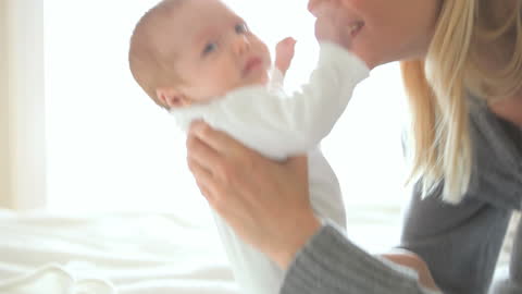 Mother Affectionately Holding Baby in Soft Light
