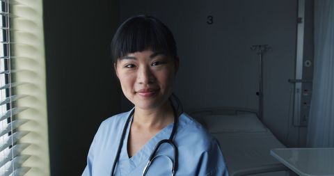 Confident Asian Nurse Standing in Hospital Room