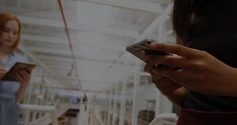 Woman in Modern Industrial Facility Using Smartphone and Tablet