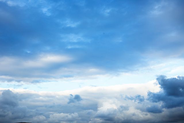 This image captures a tranquil blue sky with various shapes of clouds, creating a serene and calming atmosphere. Perfect for use in projects related to weather forecasting, travel agency promotions, outdoor activities, and meditation or relaxation materials.