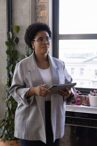 Confident Businesswoman in Modern Office Environment with Tablet