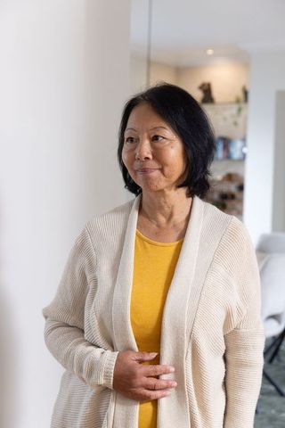 Elegant Senior Asian Woman Standing in Cozy Living Room
