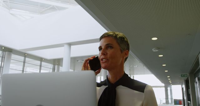 Businesswoman with short hair on phone in modern office - Download Free Stock Images Pikwizard.com
