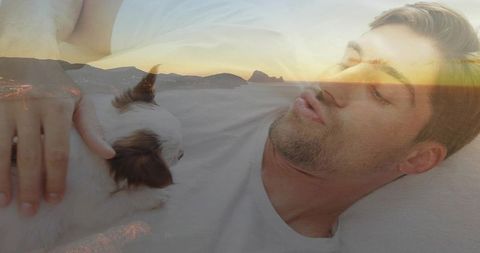 Man relaxing with puppy overlooking serene coastal sunset