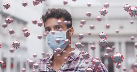 Man wears face mask surrounded by 3d covid-19 virus cells