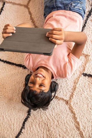 Asian preteen boy with tablet listening to music