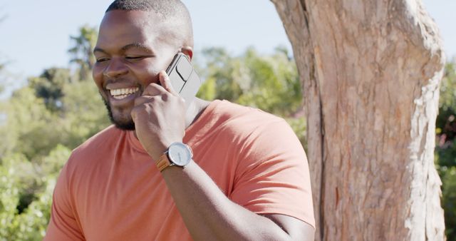 Smiling man talking on smartphone in park - Download Free Stock Images Pikwizard.com