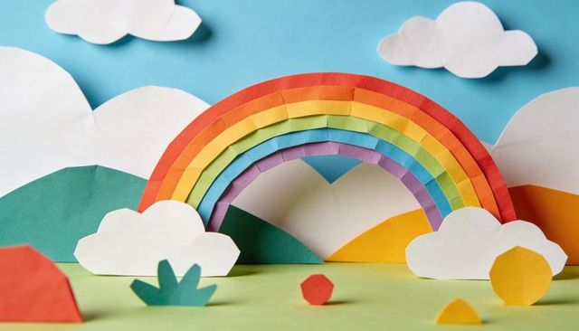 Displaying layered paper rainbow diorama with handcrafted clouds, colorful hills, cutouts