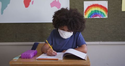 Child Wearing Face Mask Writing in Classroom Notebook - Download Free Stock Images Pikwizard.com