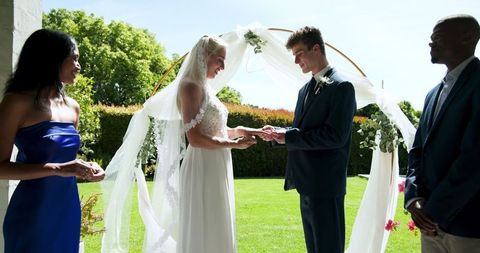Multicultural wedding ceremony outdoors with celebrating guests