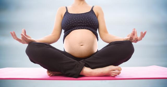 Digital composite of Pregnant woman meditating against blurry blue wood panel