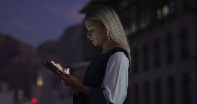 Businesswoman Typing on Tablet at Night in Urban Setting - Download Free Stock Images Pikwizard.com