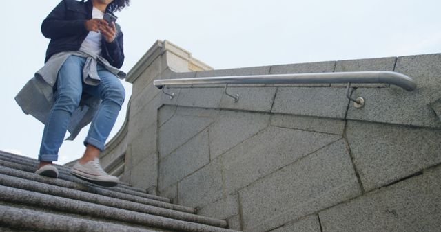 Low section of biracial man walking down steps using smartphone in city street, copy space - Download Free Stock Photos Pikwizard.com
