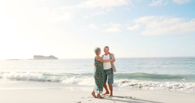 Senior couple dancing on sandy beach with gentle waves and sunrise in background, symbolizing love and joy in retirement. Photo ideal for travel brochures, lifestyle blogs, articles about senior activities and relationships, romantic getaway promotions.