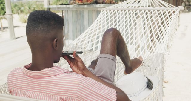 Man Relaxing in Hammock on Tropical Beach Using Smartphone - Download Free Stock Images Pikwizard.com