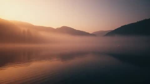 Sunrise Mist Over Mountain Lake with Enveloping Forested Hills