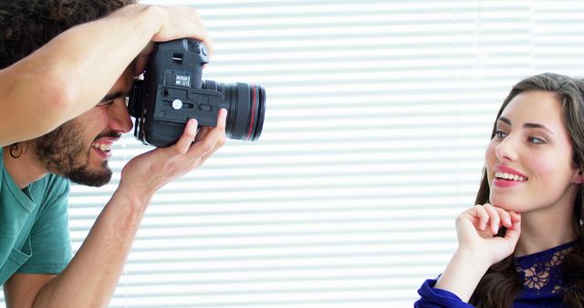 Photographer capturing portrait of a smiling woman in a studio environment. Useful for articles about photography techniques, professional relationships in creative fields, and portraiture. Ideal for content related to photography workshops, studio equipment, or personal training sessions.