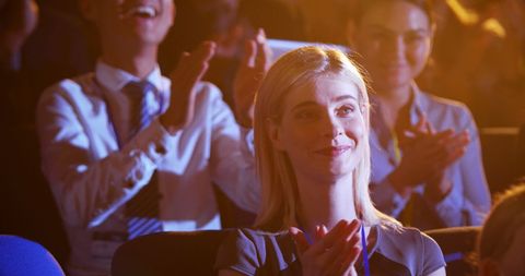 Professional Woman Smiling and Applauding at Conference