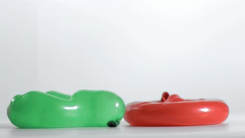 Green and Red Balloons Bouncing in Slow Motion