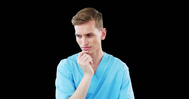 Thoughtful Healthcare Professional in Blue Scrubs against Black Background - Download Free Stock Images Pikwizard.com