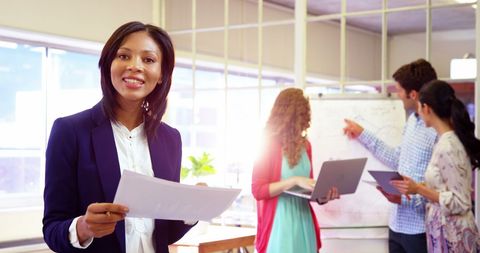 Confident Businesswoman Leading Creative Team in Modern Office