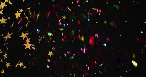 Golden stars falling and shimmering on black with multicolor foil confetti and glitter