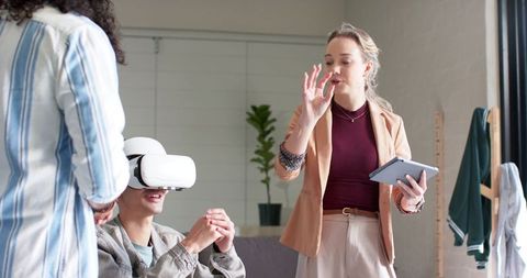 Team leader presenting virtual reality training while colleague using vr headset in office