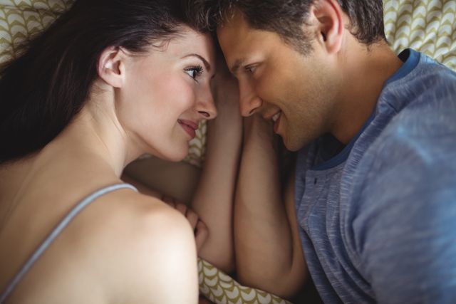 Romantic Couple Relaxing on Bed and Smiling - Download Free Stock Photos Pikwizard.com
