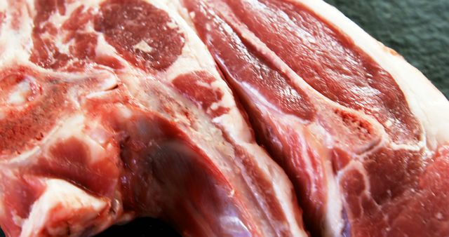 High-resolution close-up of fresh raw lamb chops showcasing rich marbling, ideal for use in cooking blogs, culinary websites, recipe books, food packaging presentations, and butcher shop advertisements. Perfect for emphasizing quality cuts of meat and enhancing appetizing visuals.