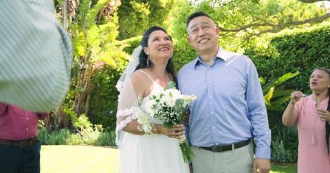 Joyful Bride and Groom with Friends at Outdoor Wedding Celebration