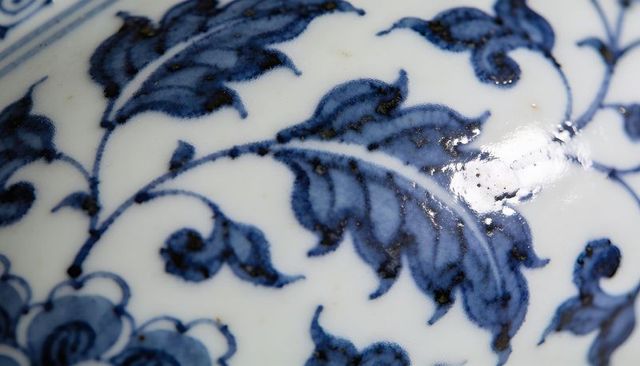 Macro detail showing hand-painting cobalt blue porcelain floral pattern on glazed surface
