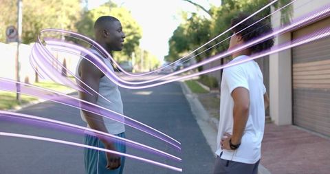 Two Men Talking on Suburban Street with Purple Light Trails and Wristwatch Accent