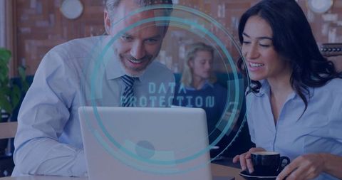 Business Professionals Reviewing Data Protection on Laptop Over Coffee in Café