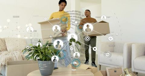 Young couple carrying moving boxes in modern living room with digital connectivity overlay