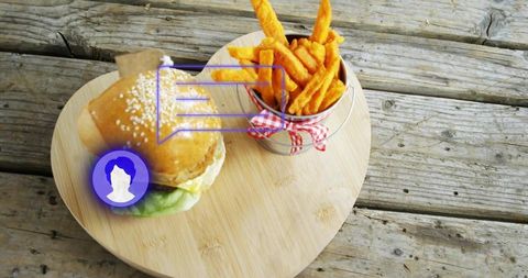 Heart-shaped bamboo board with burger and fries and purple ar overlay on wood table