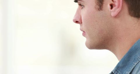 Contemplative young man in denim shirt with copy space