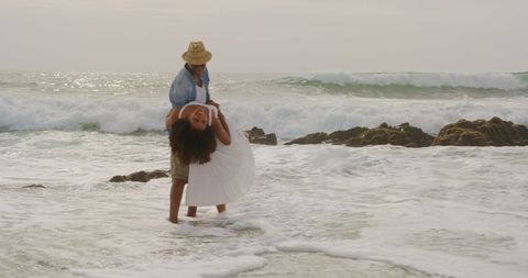Joyful Couple Dancing on Beach in Fun Beachwear
