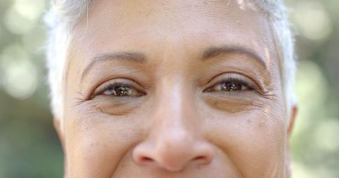 Close-Up of Happy Senior Woman with Short Grey Hair in Sunshine
