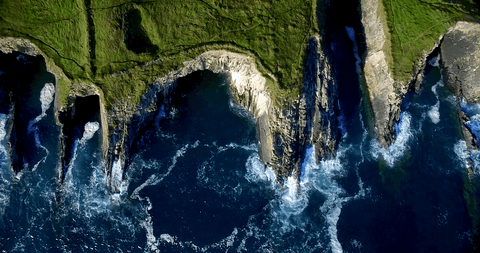 dramatic aerial view of transparent waves crashing against majestic cliffs - Download Free Stock Videos Pikwizard.com